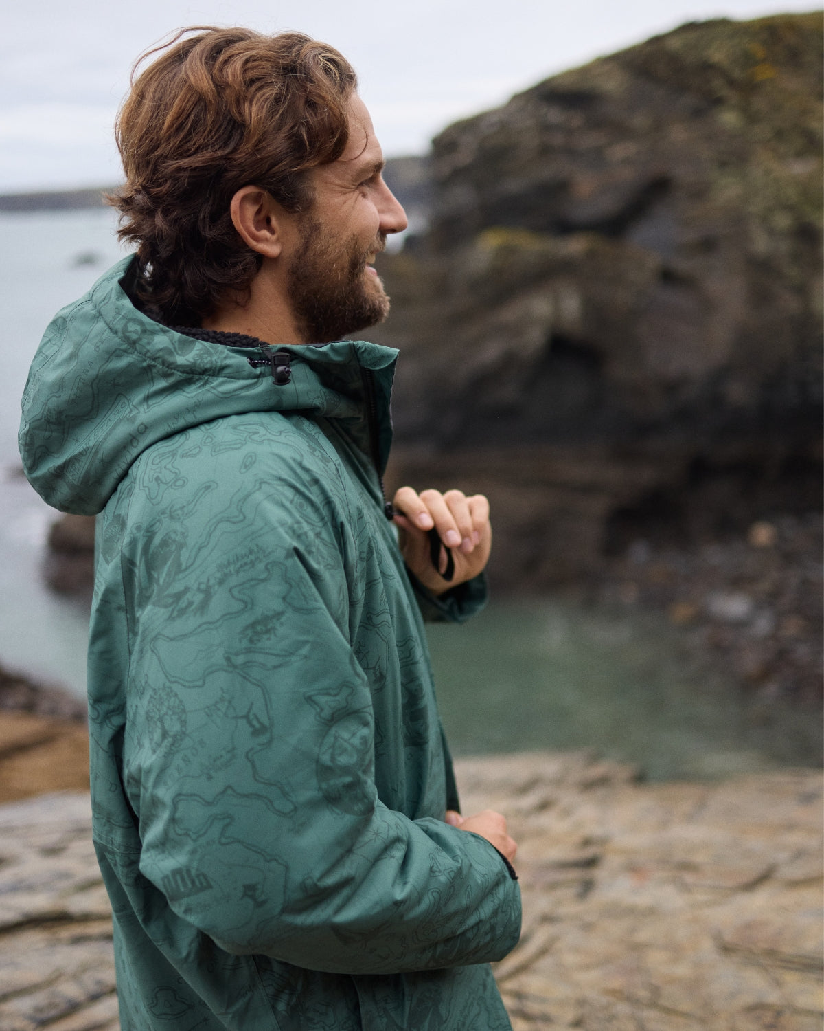 Man wearing a Vivida sherpa weatherproof changing robe Green Map of Dreams