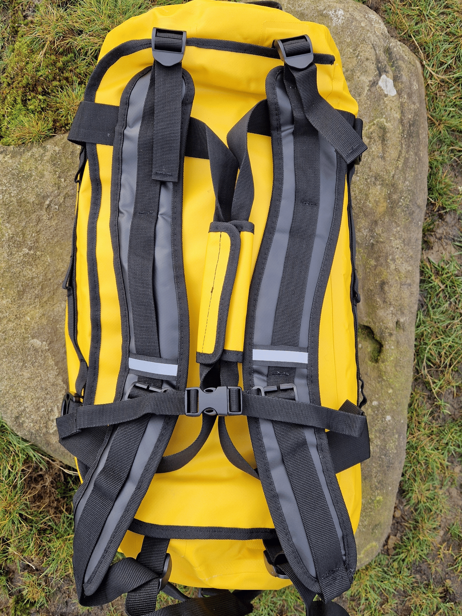 view from above of a bright yellow duffel bag to show the removable backpack straps