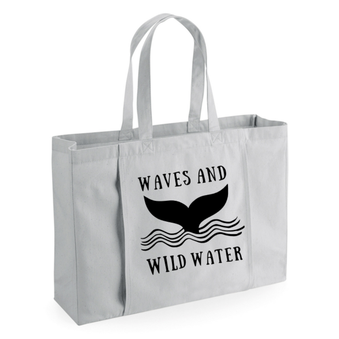 This multi-purpose shoulder bag from Waves and Wild Water features the majestic whale tail logo in black print on a light grey background bag. Loved by wild swimmers and sea dippers because it holds so much kit!