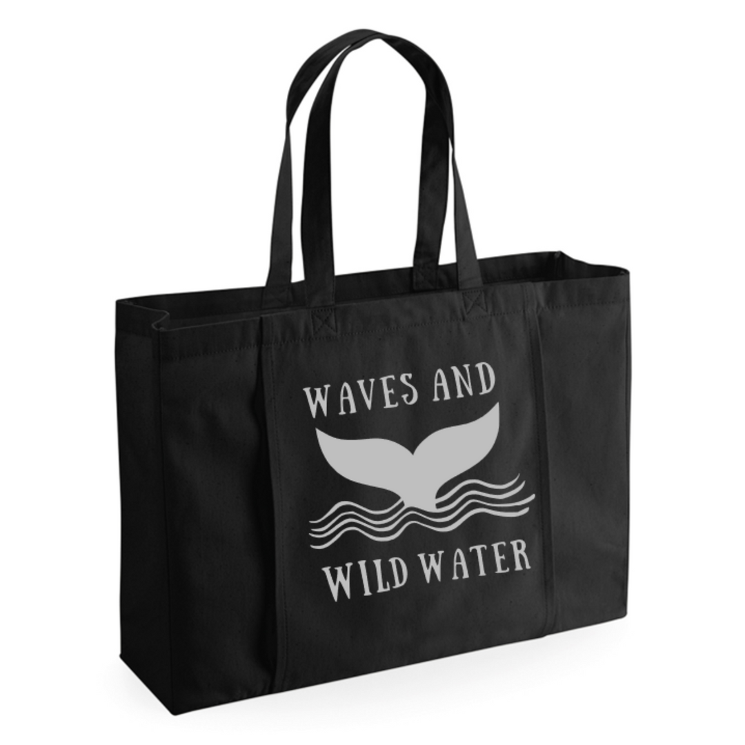 Black Towel Tote bag with the Waves and Wild Water whale tail logo in metallic silver print. This bag is great for wild swimmers and sea dippers because of its large capacity and front towel storage.