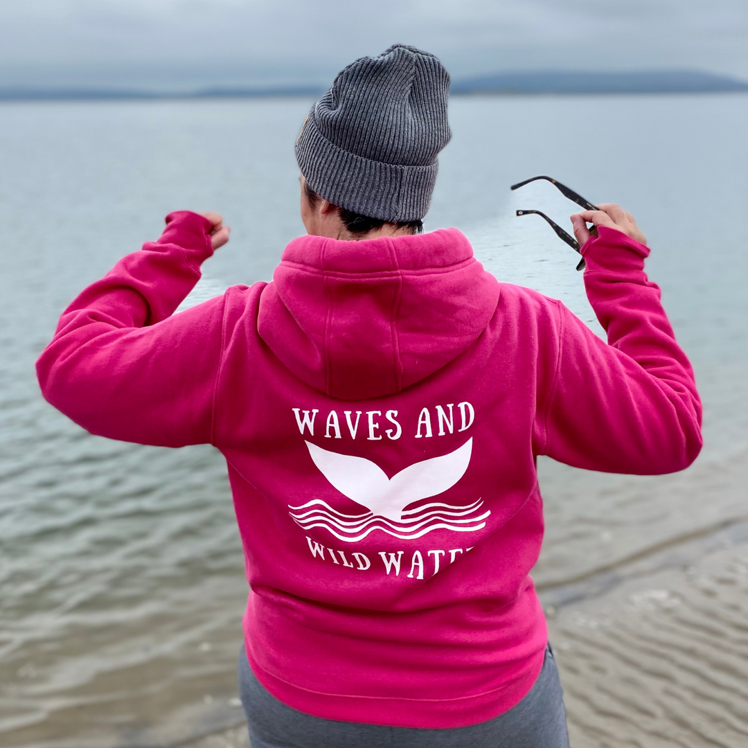 It may be a cold grey day at the beach, but Waves and Wild Water owner Claire, is warm and snuggly in her heavyweight, super soft hoodie with thumb holes. And the bright pink hoodie with contrasting white logo print is colourful enough to chase away even the gloomiest of days.