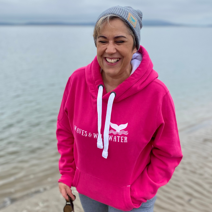 Waves and Wild Water owner Claire, laughs on the beach in South Wales as she contemplates going for a cold water swim in he sea... It's a good job she's got her super-warm hoodie in bright pink to keep her warm afterwards!