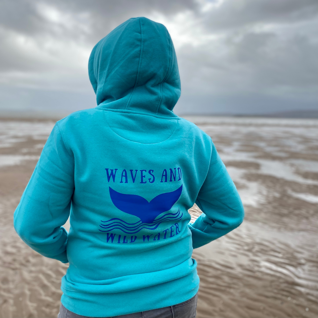 The back of our bestselling Waves and Wild Water heavyweight hoodie, in lagoon blue with deep blue print. The hoodie shows our fabulous whale tail logo, which appeals to wild swimmers and mermaids alike!